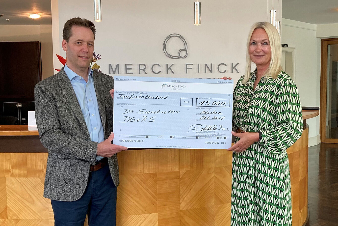 Vorstandsmitglied der Merck-Finck-Stiftung (r.), überreicht DGzRS-Mitarbeiter Andreas Meyer (l.) einen symbolischen Spendenscheck.