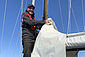 Mark Eichberger steht an Bord seines Segelbootes am Segelmast.